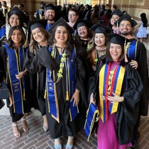 MHA Graduates wearing regalia standing outside Royce Hall, UCLA.